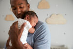 dad holding newborn in nursery
