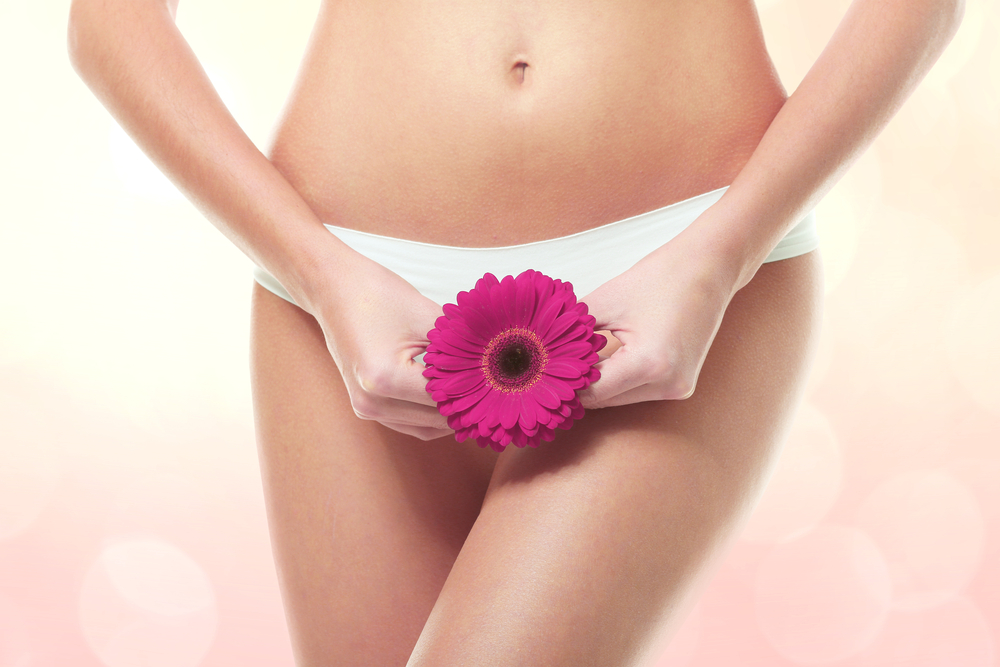 woman body with flower over pelvic area
