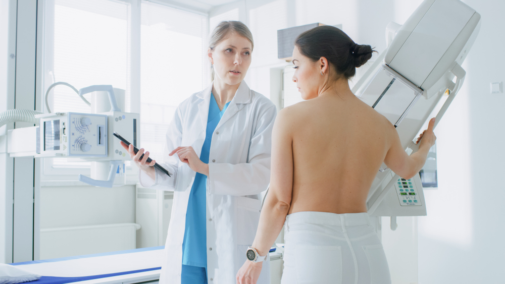 patient and physician discussing mammogram by the machine