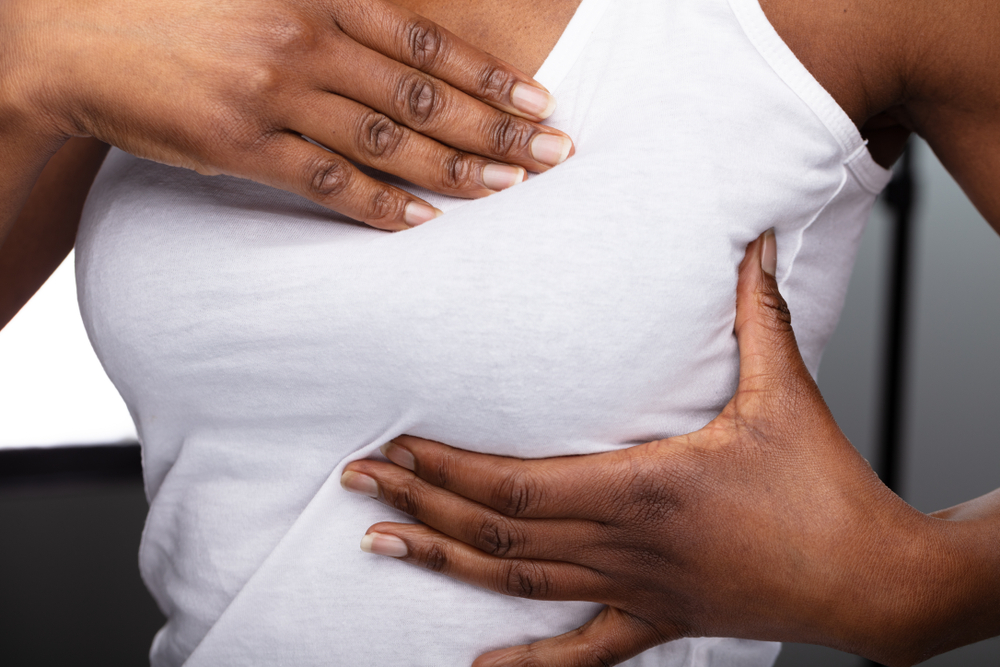 Woman suffering with breast pain from mastitis.