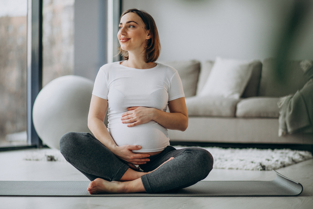 Pregnant woman on exercise mat.