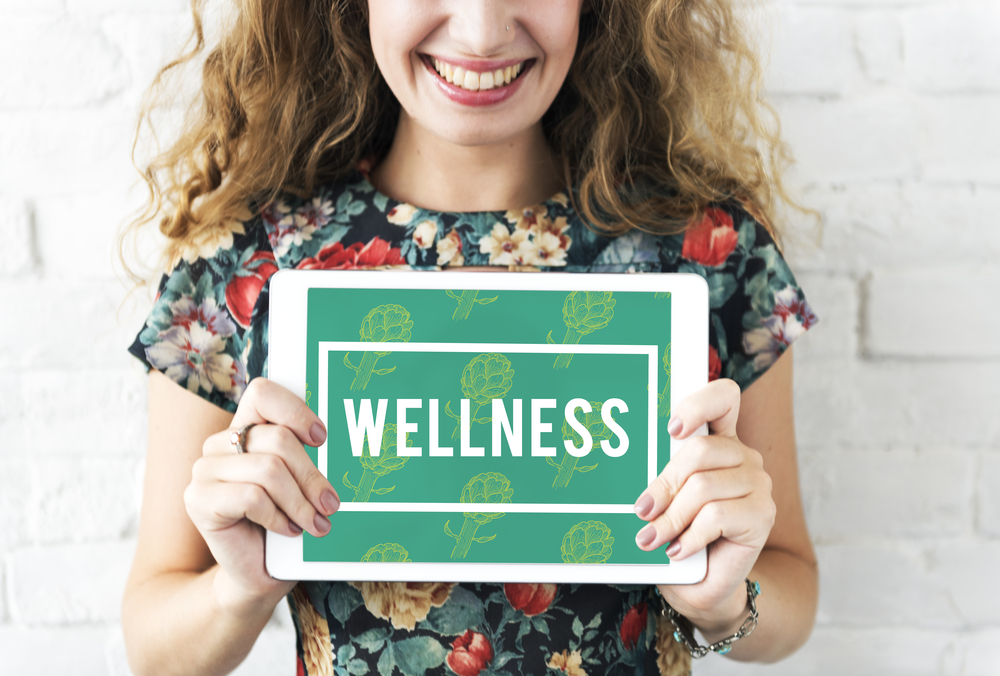 Woman Holding Sign Saying Wellness