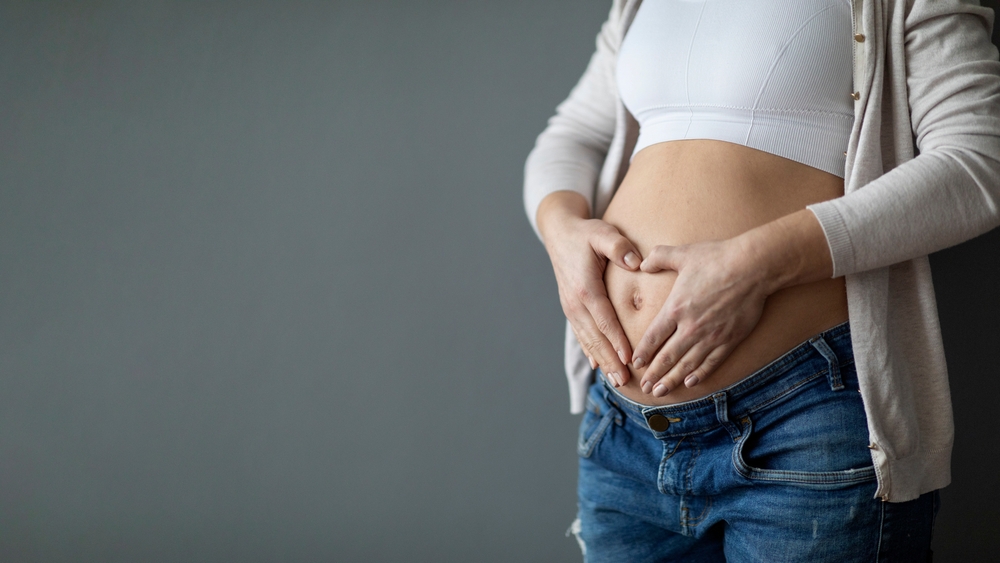 pregnant woman holding her stomach.